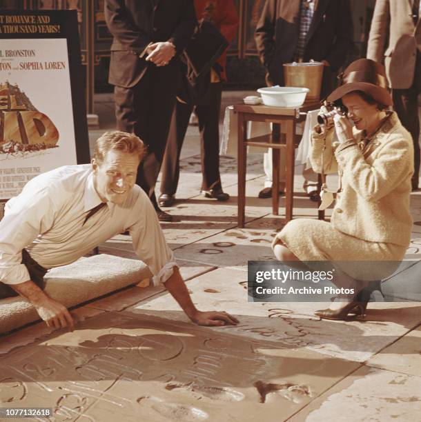 American actor Charlton Heston signs his name in cement under his handprints outside Grauman's Chinese Theatre, Hollywood, California, 18th January...