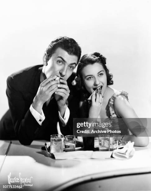 American pianist and bandleader Eddy Duchin shares a snack with singer Durelle Alexander , 1938.