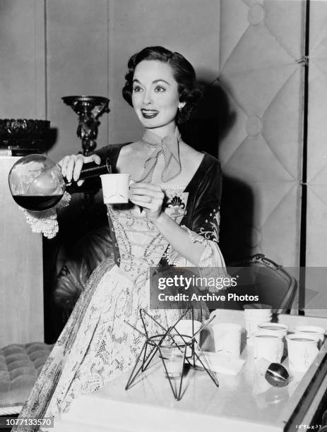 American actress Ann Blyth pours coffee on the set of the film 'The Student Prince', circa 1954.