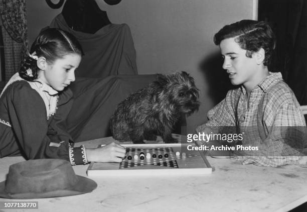 Co-stars Virginia Weidler and Gene Reynolds playing Chinese checkers on the set of the MGM film 'Patsy', later titled 'Bad Little Angel', 1939. They...