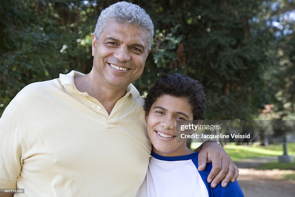 Hispanic father with arm around son