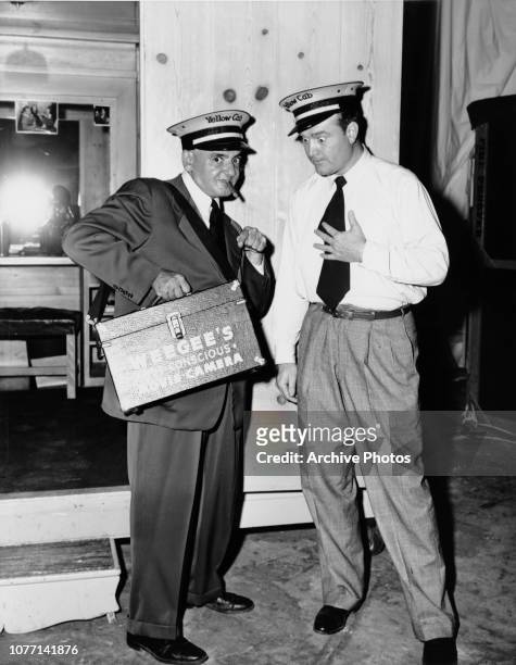 Photographer Weegee , aka Arthur Fellig, shows 'Weegee's Sub Conscious Movie Camera' to actor Red Skelton on the set of the MGM film 'The Yellow Cab...