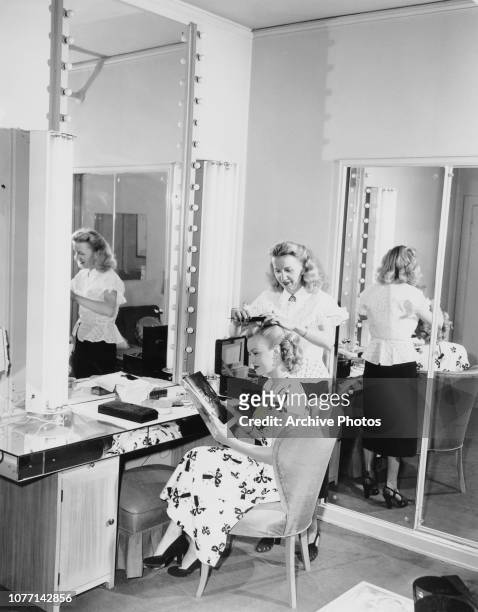 American actress June Haver has her hair done by a studio stylist, circa 1950.