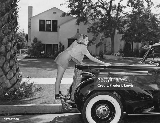 American singer and actress Judy Garland polishes her 1939 Packard Six during the filming of the MGM musical 'The Wizard of Oz', 1939.