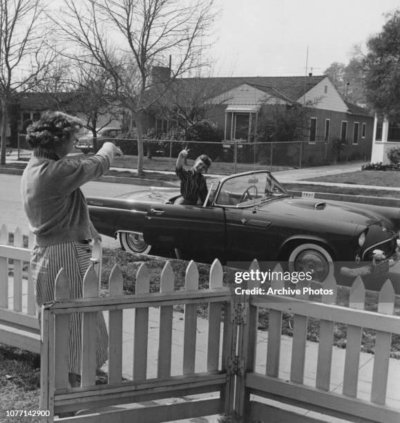 American actress and singer Debbie Reynolds waves goodbye to her mother from her 1955 Ford Thunderbird convertible, 4th March 1955.