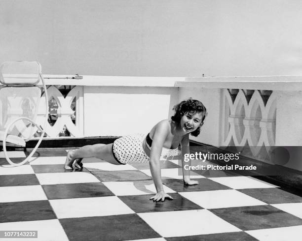 American actress Mitzi Gaynor doing her exercises on the terrace, 1953.