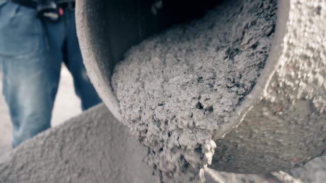 SLO MO Fresh concrete being poured out of the drum of the concrete mixer