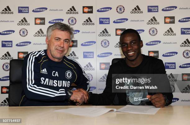 Gael Kakuta of Chelsea signs a new contract in the presence of Chelsea manager Carlo Ancelotti at the Cobham training ground on December 21, 2010 in...