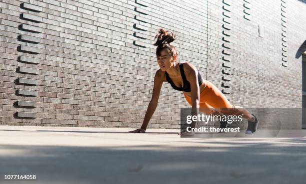 een mooie vrouw doen push-ups op de straat van new york - plank exercise stockfoto's en -beelden