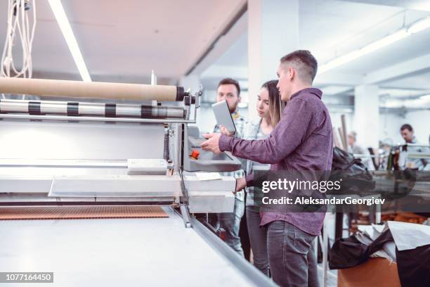 textile workers learning how to use a new machine - textile printing stock pictures, royalty-free photos & images