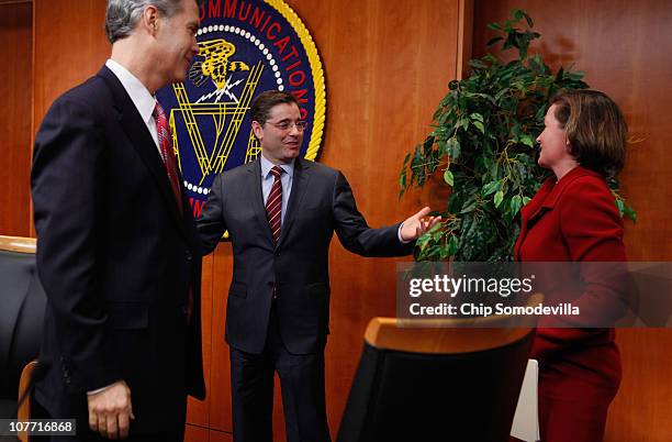 Federal Communications Commission Chairman Julius Genachowski talks with commissioners Robert McDowell and Meredith Attwell Baker after the...