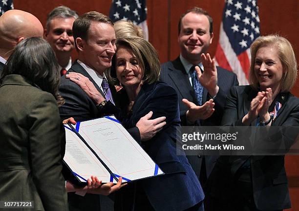 Former U.S. Air Force Major Michael D. Almy hugs House Speaker Nancy Pelosi after she signed legislation repealing the military policy law during a...