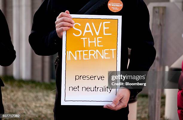 Timothy Karr of the Free Press holds a sign in support of net-neutrality before a hearing at the U.S. Federal Communications Commission in...