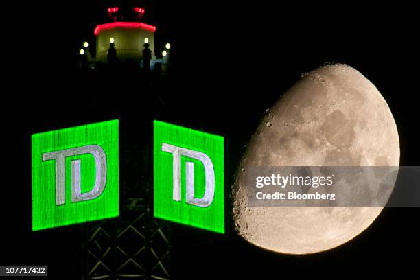 The Moon is seen beyond a Toronto-Dominion Bank logo displayed atop the TD Canada Trust Tower in the financial district of Toronto, Ontario, Canada,...