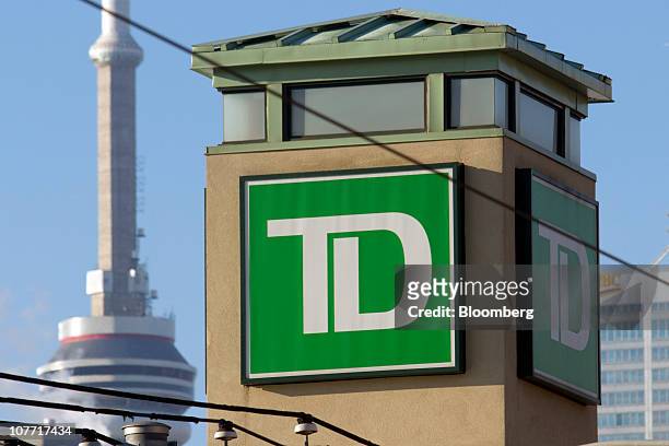 The Toronto-Dominion Bank logo is displayed on a newly-opened branch near the CN Tower, back left, in Toronto, Ontario, Canada, on Tuesday, Dec. 21,...