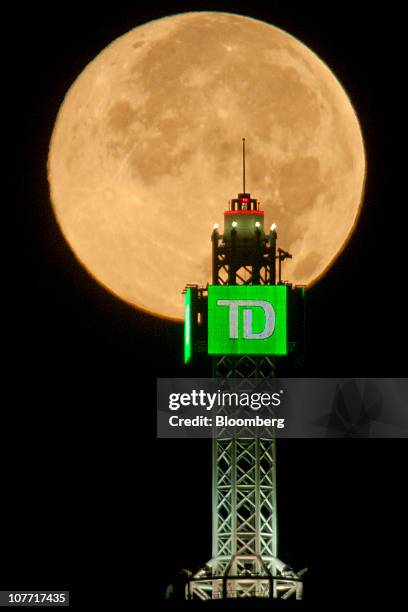 The Moon is seen beyond a Toronto-Dominion Bank logo displayed atop the TD Canada Trust Tower in the financial district of Toronto, Ontario, Canada,...