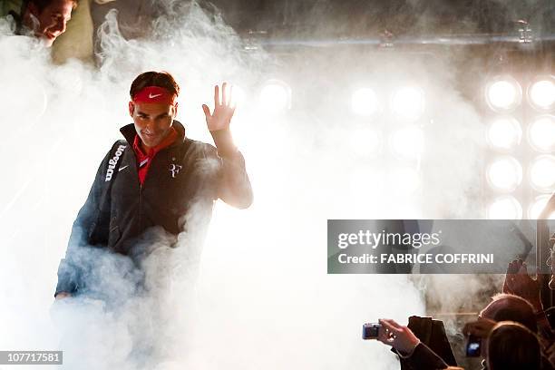 Switzerland's Roger Federer waves to spectators as he arrives to play against Spain's Rafael Nadal during a charity tennis game on December 21, 2010...