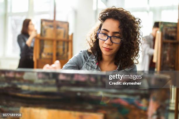 vrouwelijke middelbare schoolstudent maken haar schilderen op een klasse in het kunstatelier. - art class stockfoto's en -beelden