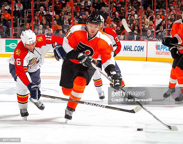 Darcy Hordichuk of the Florida Panthers defends against Andrej Meszaros of the Philadelphia Flyers as he skates up ice during a hockey game at the...