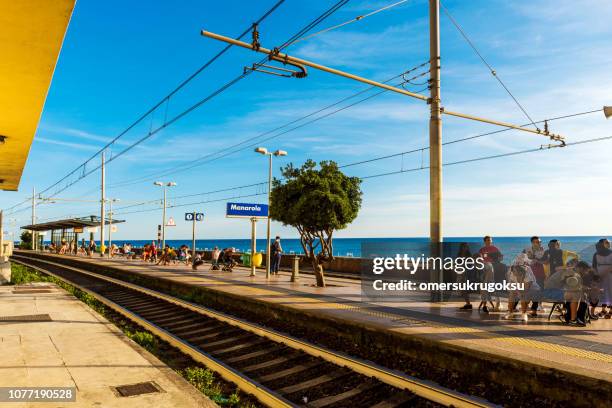 people are waiting at train station in manarola, cinque terre, italy - manarola stock pictures, royalty-free photos & images