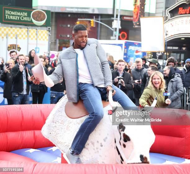 Sarah Haines cheers on Michael Strahan riding a Mechanical Bull during a Good Morning America filming promoting PBR: Unleash the Beast in Times...