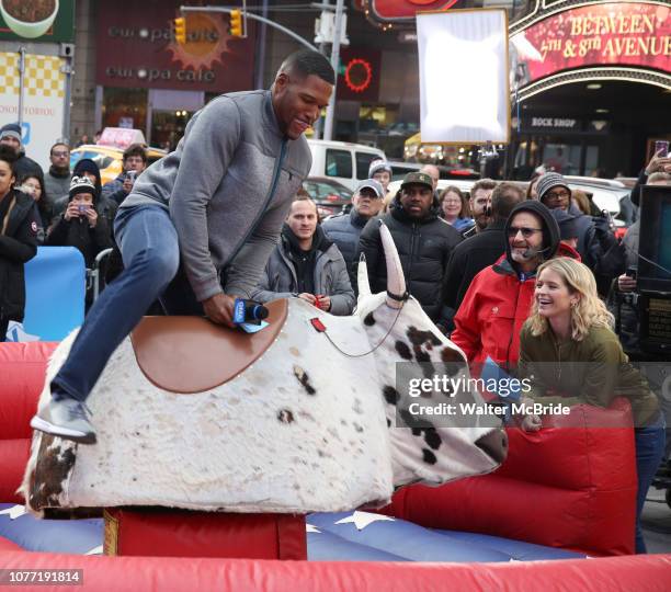 Sarah Haines cheers on Michael Strahan riding a Mechanical Bull during a Good Morning America filming promoting PBR: Unleash the Beast in Times...