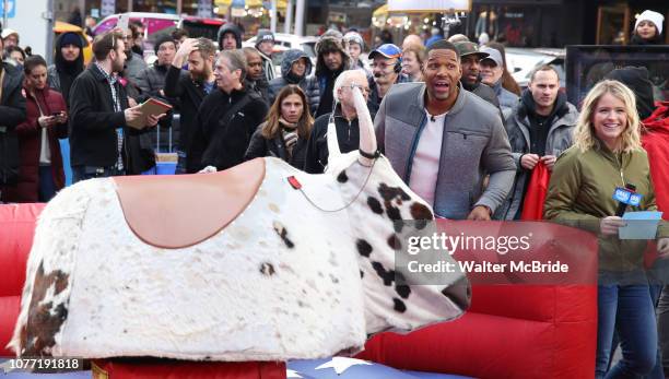 Sarah Haines cheers on Michael Strahan riding a Mechanical Bull during a Good Morning America filming promoting PBR: Unleash the Beast in Times...