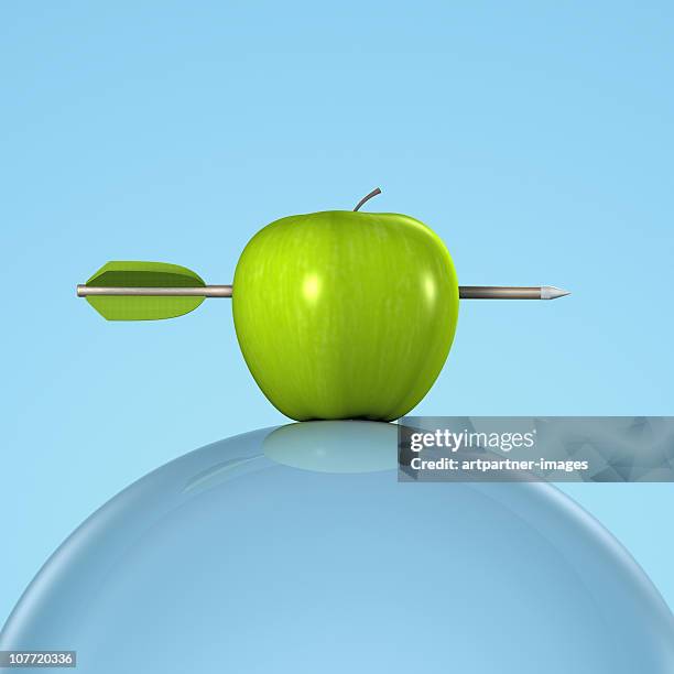 arrow in a green apple on a glass sphere - apple arrow stock-fotos und bilder