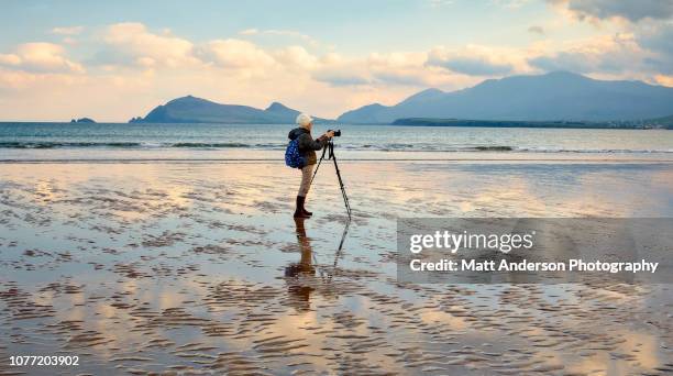woman photographing at smerwick harbor - ireland travel stock pictures, royalty-free photos & images