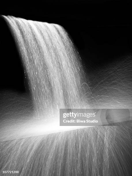 waterfall splashing on black background - waterfall photos et images de collection