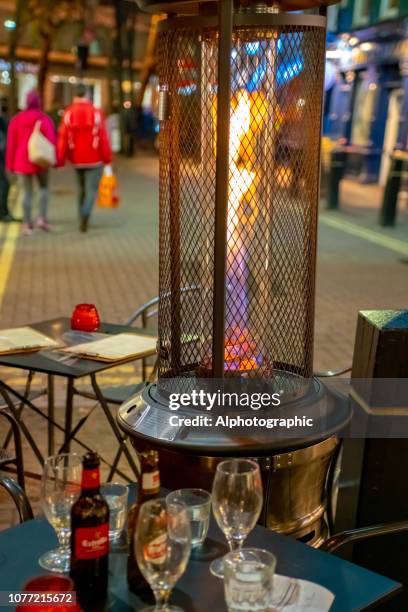 outside heater at a street café - electric heater patio stock pictures, royalty-free photos & images