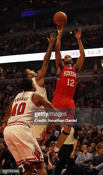 Evan Turner of the Philadelphia 76ers puts up a shot over Derrick Rose and Kurt Thomas of the Chicago Bulls at the United Center on December 21, 2010...