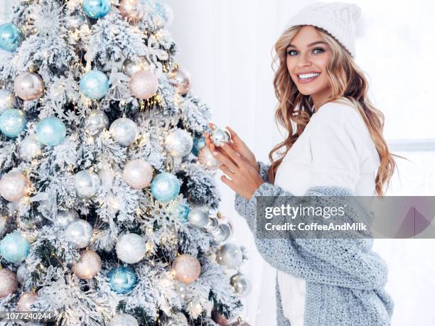 beautiful girl decorates a christmas tree - beautiful woman christmas stock pictures, royalty-free photos & images