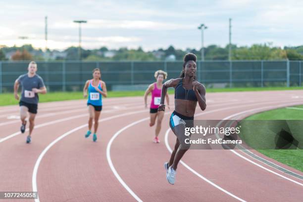 track athletes in a race - university athletics stock pictures, royalty-free photos & images