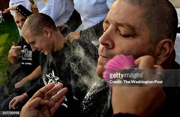 Capt. Rudy Eversburg get powdered after he had his head and mustache shaved for charity. . He's from Arlington Engine Co. 107. Far left is fellow...