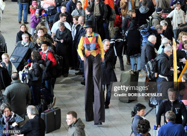 Clown walking on stilts trys to entertain air passengers as they wait for flights at the airport the central German city of Frankfurt am Main on...