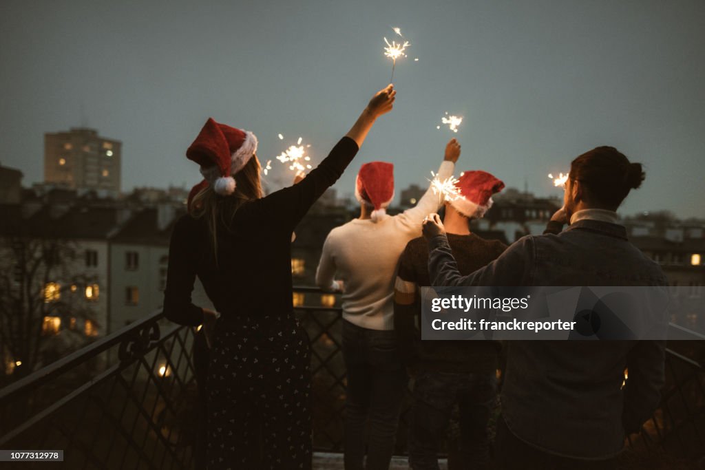 Freunde feiern Weihnachten auf dem Dach
