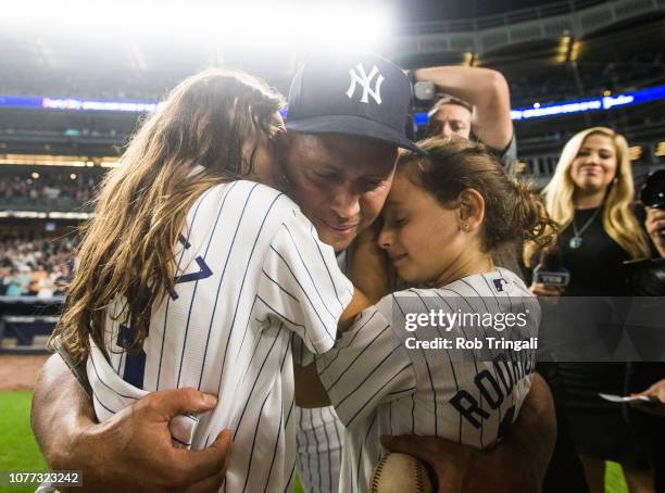 Alex Rodriguez of the New York Yankees hugs his daughters Natasha and Ella in what would be his last game as a New York Yankee player after the game...