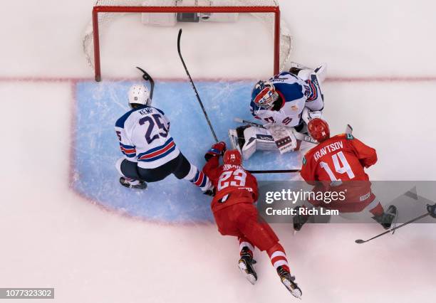 Phil Kemp of the United States clears the puck of the goal crease after it got past goalie Cayden Primeau of the United States and before Ivan...