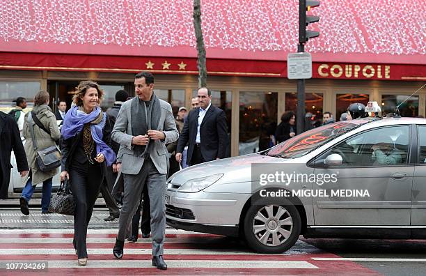 Syrian president Bashar al-Assad and his wife Asma walk in a street of Paris on December 10, 2010. Al-Assad is on a two-days official visit to...