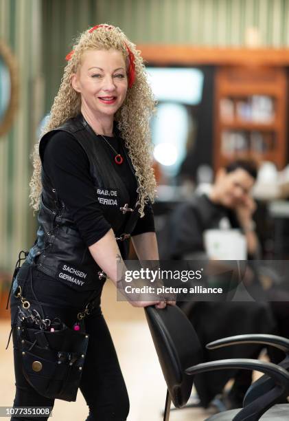 December 2018, Saxony, Freital: Hairdresser Claudia Mihaly-Anastasio is standing in her leather cowl in the hairdresser's salon. She is engaged as...