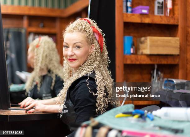 December 2018, Saxony, Freital: Hairdresser Claudia Mihaly-Anastasio sits in her leather robe in the hairdresser's salon. She is engaged as "Barber...