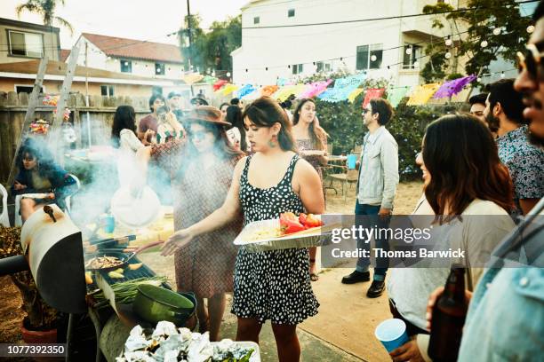 women grilling food on barbecue during backyard party with friends - cooking event foto e immagini stock