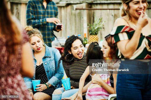 laughing woman playing with young girl during backyard barbecue on summer evening - family bbq stock-fotos und bilder