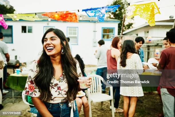 laughing woman hanging out with friends during backyard party - name tag stock-fotos und bilder