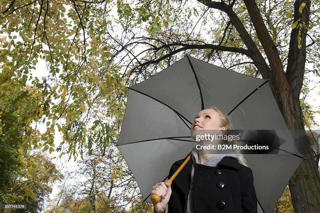 Woman holding an umbrella in a forest