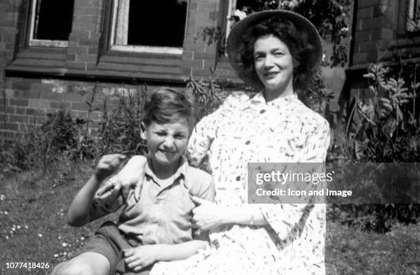 Nine year old John Lennon poses for a portrait with his mother Julia in the front garden of "Ardmore" which was the name of the home of John's...