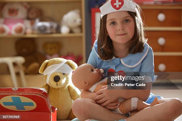 young girl playing nurse with her toys - doll fotografías e imágenes de stock