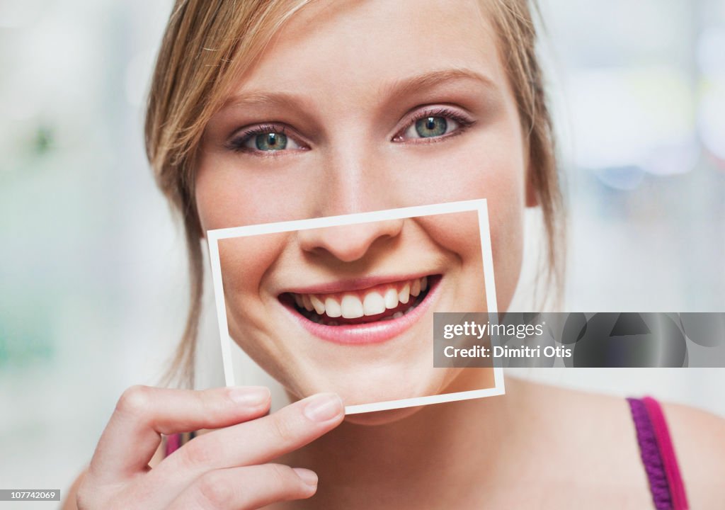 Woman with picture of her smile over her mouth