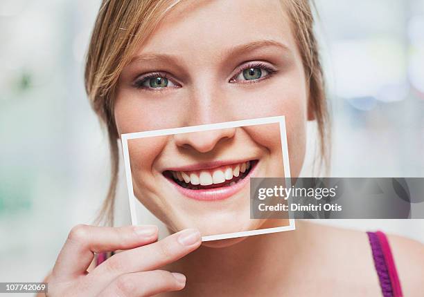 woman with picture of her smile over her mouth - human teeth 個照片及圖片檔